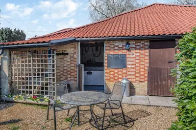a small brick house with a table and chairs at The Hayloft in Ashill