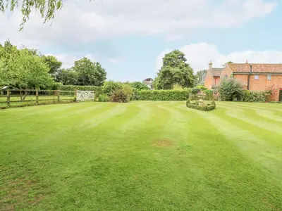 a large lawn in front of a house at The Hayloft in Ashill