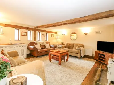 a living room with couches and a tv at The Hayloft in Ashill