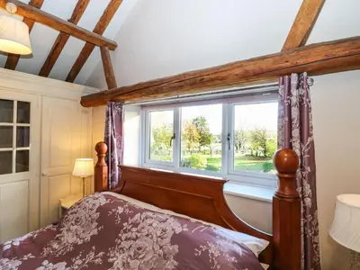 a bedroom with a bed and a window at The Dairy in Ashill
