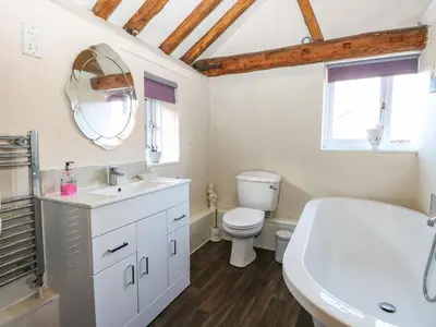 a bathroom with a sink toilet and a mirror at The Dairy in Ashill
