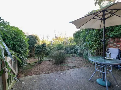 a table with an umbrella in a garden at The Dairy in Ashill