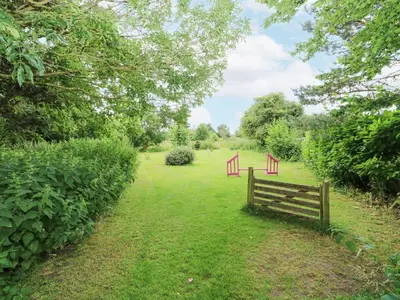 a wooden fence in the middle of a field at The Dairy in Ashill