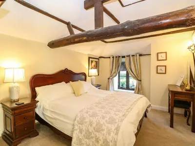a bedroom with a large bed and a window at The Barn in Ashill