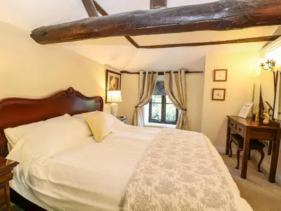 a bedroom with a large white bed and a window at The Barn in Ashill