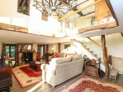 a living room with a white couch and a staircase at The Barn in Ashill