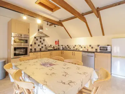a kitchen with a table and chairs in a kitchen at Hayloft Cottage in Little Glenham