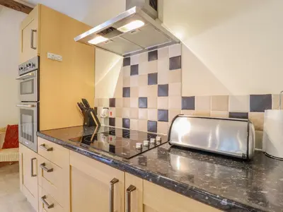 a kitchen with a sink and a counter top at Hayloft Cottage in Little Glenham