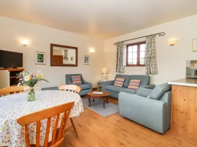a living room with a couch and a table at Barn Owl Cottage in Little Glenham