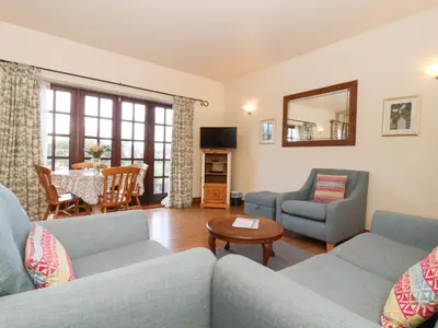 a living room with two couches and a table at Barn Owl Cottage in Little Glenham