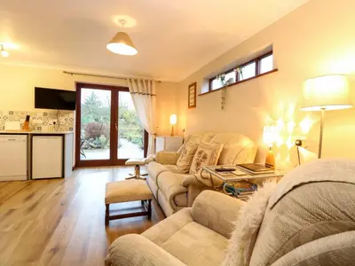 a living room with a couch and a table at Kingfisher in Wattisfield