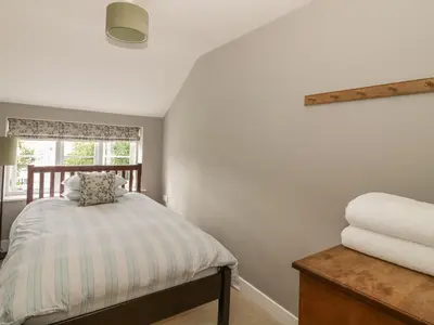 a small bedroom with a bed and a window at Mulberry Cottage in Hadleigh