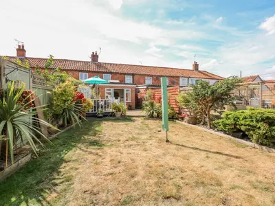 an exterior view of a house with a yard at Holly Cottage in Swaffham