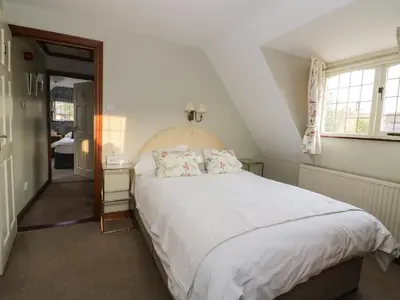 a bedroom with a large white bed and a window at The Lodge off High Street in Hadleigh