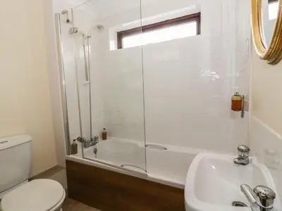 a bathroom with a shower and a toilet and a sink at The Lodge off High Street in Hadleigh