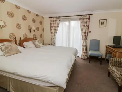 a bedroom with a bed and a desk with a computer at The Lodge off High Street in Hadleigh