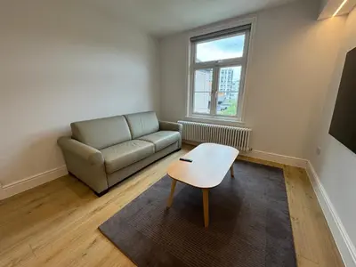 a living room with a couch and a table at Brentwood Hotel & Apartments in Brentwood