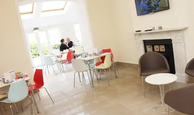 a restaurant with tables and chairs and a fireplace at Brentwood Hotel & Apartments in Brentwood
