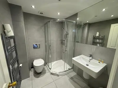 a bathroom with a shower and a sink and a toilet at Brentwood Hotel & Apartments in Brentwood