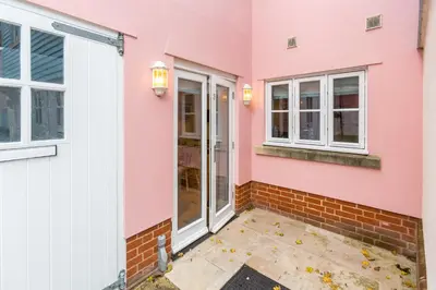 a pink house with a door and windows at The Lobster Pot in Aldeburgh
