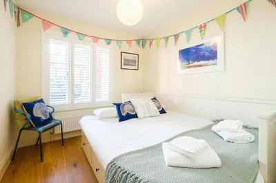 two twin beds in a room with flags on the wall at Shell Cottage in Aldeburgh