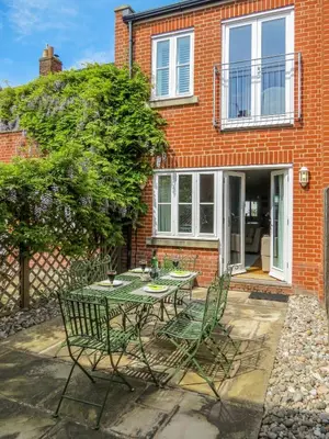 a table and chairs in front of a brick house at Shell Cottage in Aldeburgh