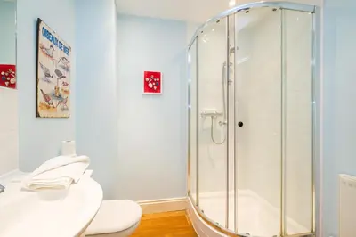 a bathroom with a shower and a toilet and a sink at Shell Cottage in Aldeburgh