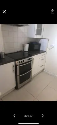 a kitchen with a black and white stove top oven at Waltham Abbey Private Property in Waltham Abbey