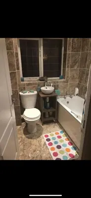 a bathroom with a toilet and a tub and a sink at Waltham Abbey Private Property in Waltham Abbey