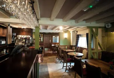 a restaurant with tables and chairs and wine glasses at The Bull at Great Totham Limited in Great Totham