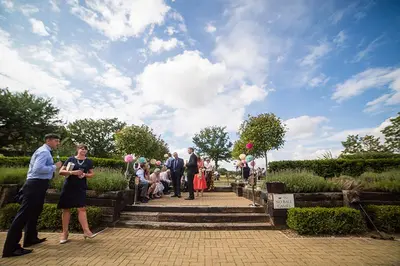 a group of people standing around in a garden at The Bull at Great Totham Limited in Great Totham