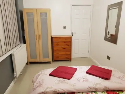 a bedroom with a bed with two red towels on it at Observation Court in Ipswich