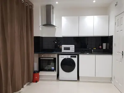 a kitchen with a washing machine and a microwave at Observation Court in Ipswich