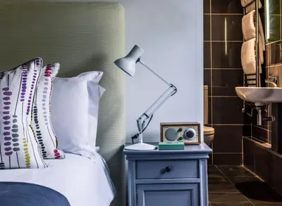 a bedroom with a bed with a lamp and a nightstand at Crown and Castle in Orford