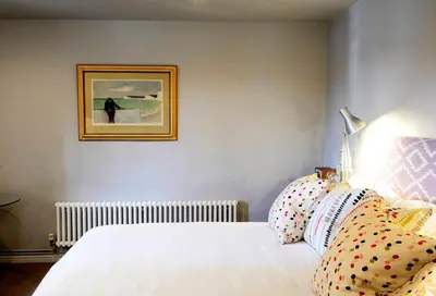a bedroom with a white bed and a picture on the wall at Crown and Castle in Orford