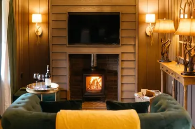 a living room with a fireplace and a tv at Retreat East in Ipswich