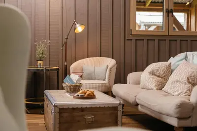 a living room with a couch and a chair and a table at Retreat East in Ipswich