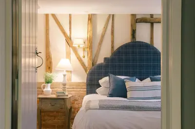 a bedroom with a bed with a blue head board at Retreat East in Ipswich