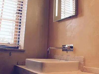 a bathroom with a sink and a mirror and windows at The Lodge at Hemingford Grey House in Hemingford Grey