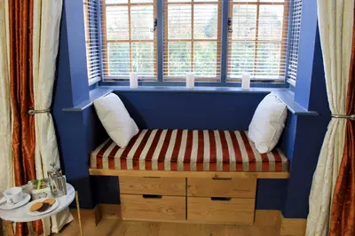 a bench in a room with a window with candles at The Lodge at Hemingford Grey House in Hemingford Grey