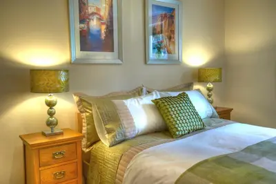 a bedroom with a bed and a nightstand with two lamps at Sunset House Bed and Breakfast in East Harling