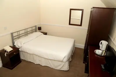 a hotel room with a bed and a mirror at Rose and Crown Hotel in Haverhill