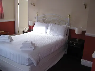 a bedroom with a white bed with towels on it at Rose and Crown Hotel in Haverhill