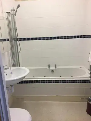 a bathroom with a bath tub and a sink at The Grosvenor in Clacton-on-Sea