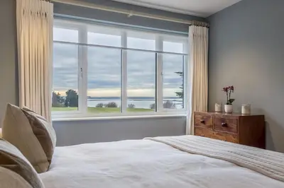 a bedroom with a bed and a large window at Marsh Lodge in Aldeburgh