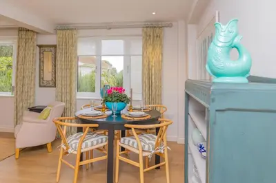 a dining room with a blue table and chairs at Marsh Lodge in Aldeburgh