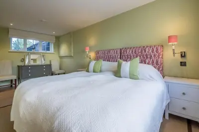 a bedroom with a large white bed with green pillows at Marsh Lodge in Aldeburgh