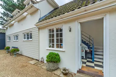 a white house with a sliding door and stairs at River View in Aldeburgh