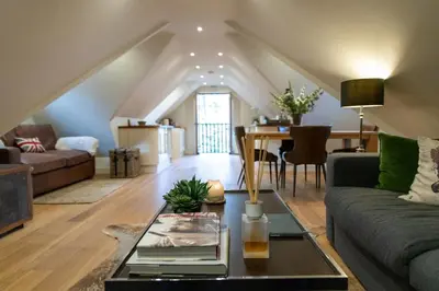 a living room with a couch and a table at Hertford Barn conversion in Hertford