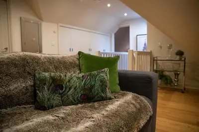 a couch with two pillows on it in a living room at Hertford Barn conversion in Hertford
